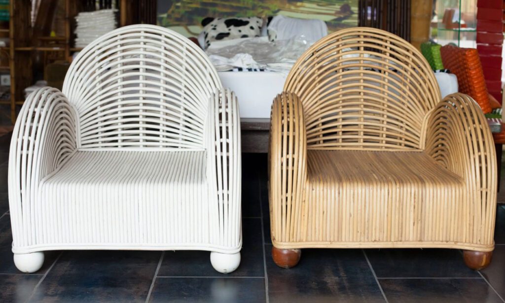 Two wicker armchairs, one white and one natural wood, side by side indoors.