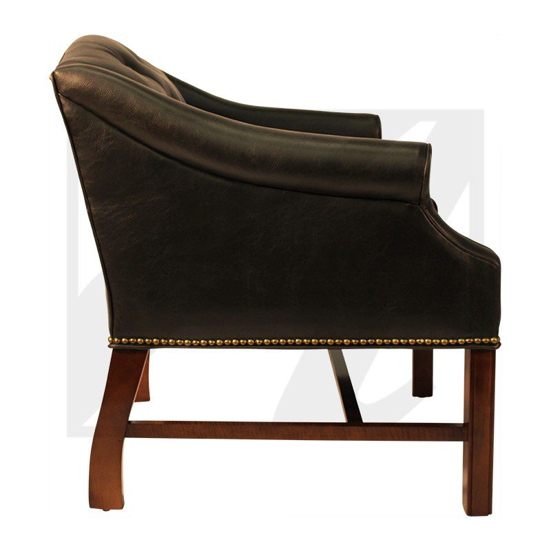 Side view of a classic armchair with dark upholstery and wooden legs.