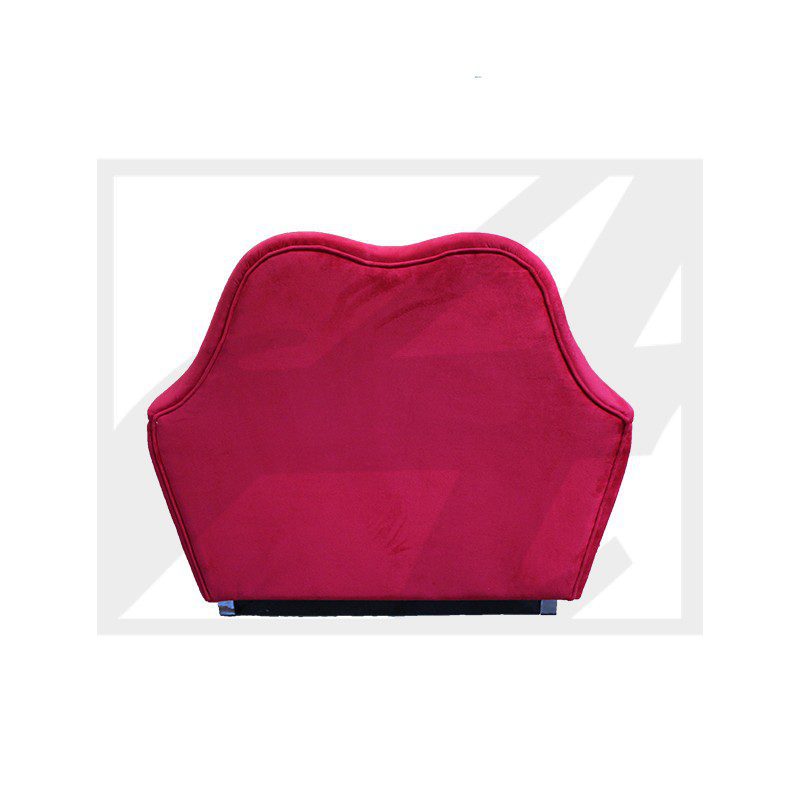 Red velvet chair with a unique wavy backrest design.
