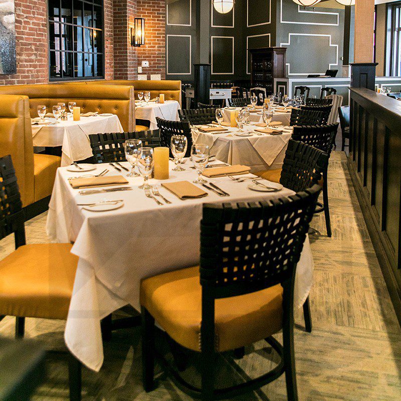 Elegant restaurant interior with neatly set tables and warm lighting.