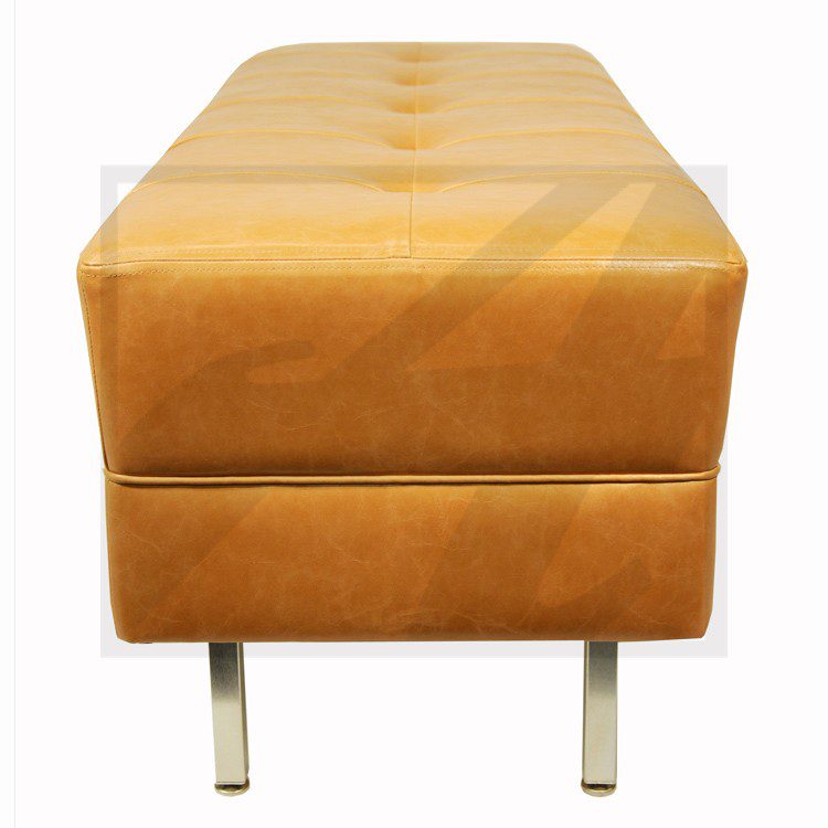 A modern brown leather bench with metal legs.