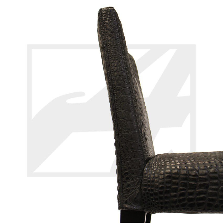 Side view of a dark woven chair with a high backrest.