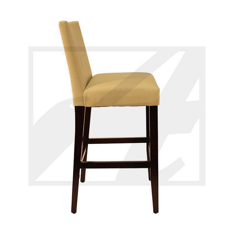 Side view of a mustard yellow upholstered bar stool with dark wooden legs.