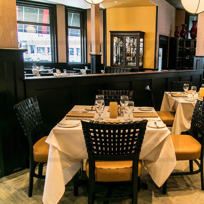Elegant restaurant dining area with neatly set tables and warm lighting.