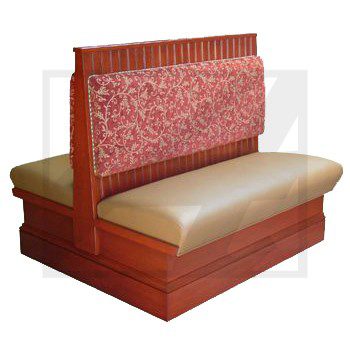 A wooden restaurant booth with beige seat and red patterned backrest.